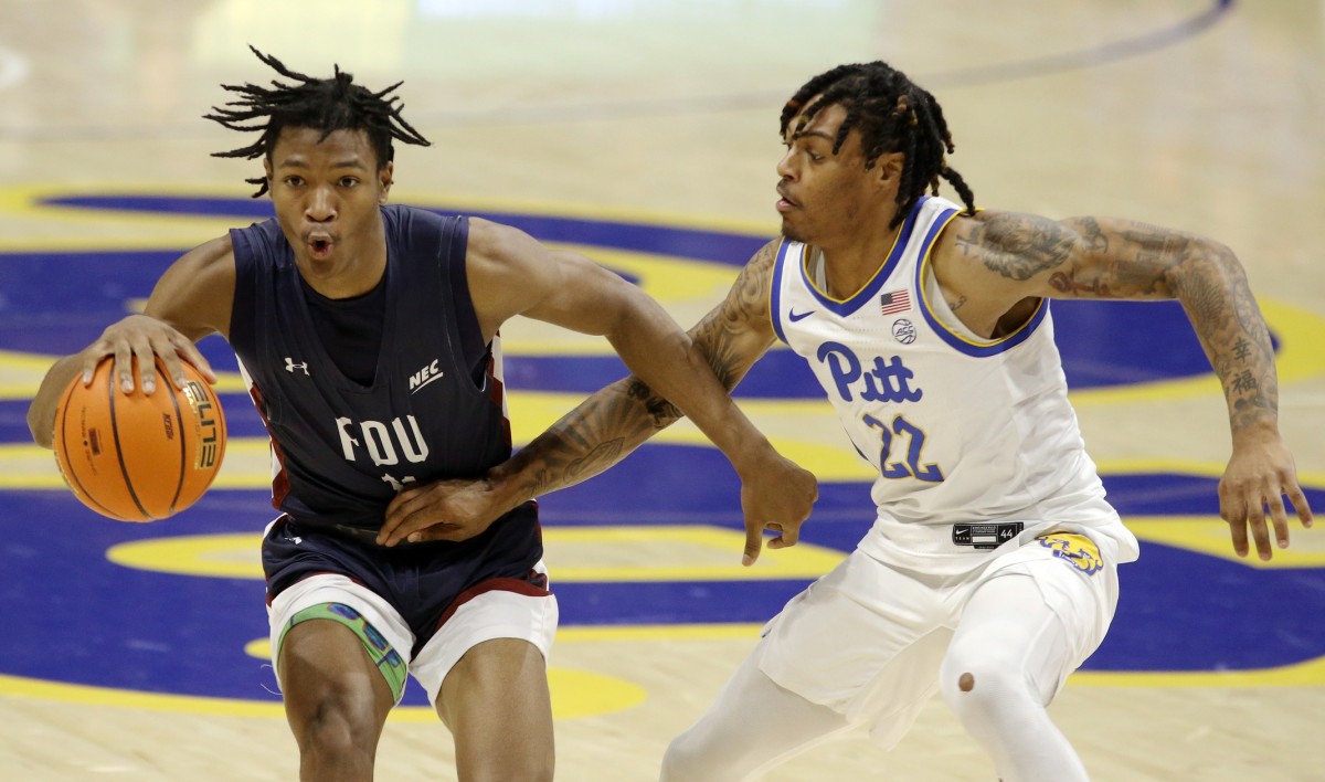 Fairleigh Dickinson Knights forward Sean Moore (11) handles the ball against Pittsburgh Panthers guard Nike Sibande (22) during the second half at the Petersen Events Center. Pittsburgh won 83-61.